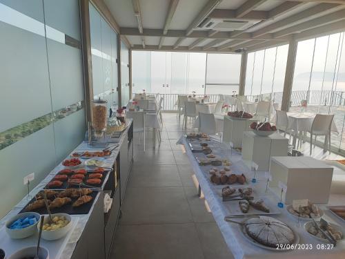 a buffet line of food on tables in a building at Hotel Antica Cascina Del Golfo in Scopello