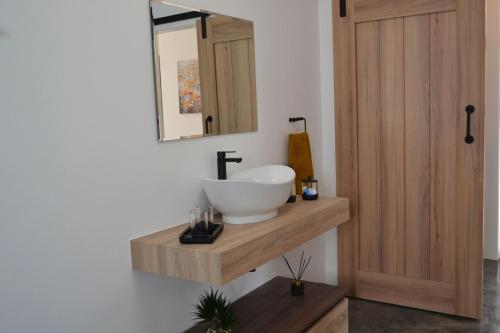 a bathroom with a sink and a mirror on a wall at Mika Self Catering Cottage in Dullstroom