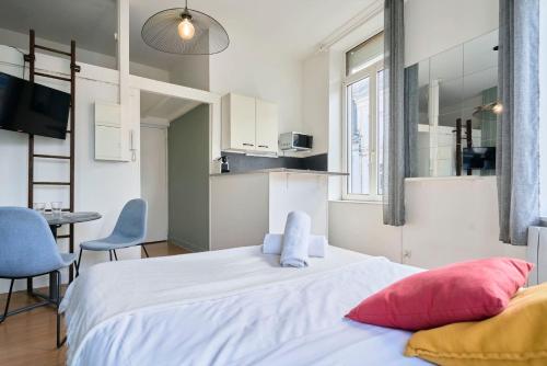 ein Schlafzimmer mit einem großen weißen Bett mit zwei Kissen in der Unterkunft Lille Saint Maurice - Nice and functional studio in Lille