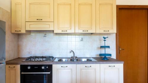 a kitchen with white cabinets and a sink at Casa dei Lidi in Budoni