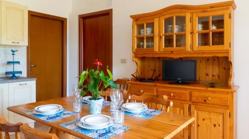 a dining room with a wooden table and a television at Casa dei Lidi in Budoni