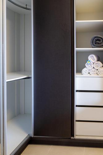 a closet with a black door and white shelves at PALMAS EXPERIENCE - APARTAMENTO BRISA, no centro, vista lago! in Palmas