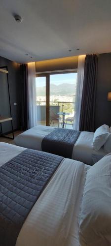 a hotel room with two beds and a balcony at Mulaj Hotel in Tirana