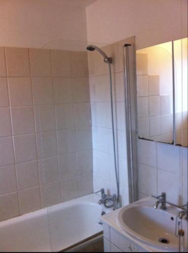 a bathroom with a bath tub and a sink at Hollowstone in London