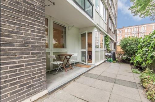 un patio con mesa y un edificio en Hollowstone en Londres