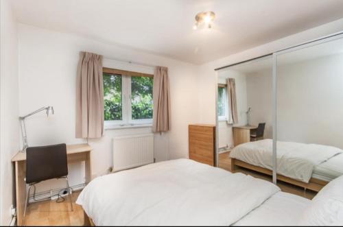 1 dormitorio con 2 camas, escritorio y silla en Hollowstone en Londres