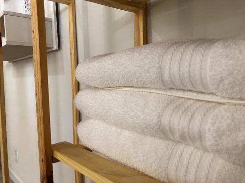 una pila de toallas en un estante de una habitación en Casa Morena Luz - espaço e conforto, perto da praia en Cumuruxatiba