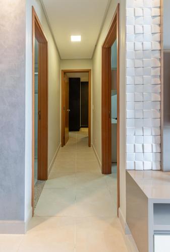 a hallway of a house with doors and tiles at PALMAS EXPERIENCE - APARTAMENTO BRISA, no centro, vista lago! in Palmas