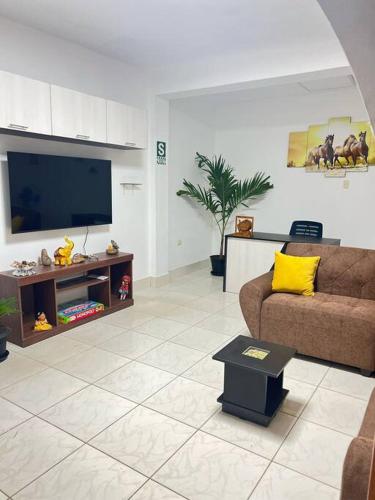 a living room with a couch and a flat screen tv at La casa de Pochita in Tarapoto