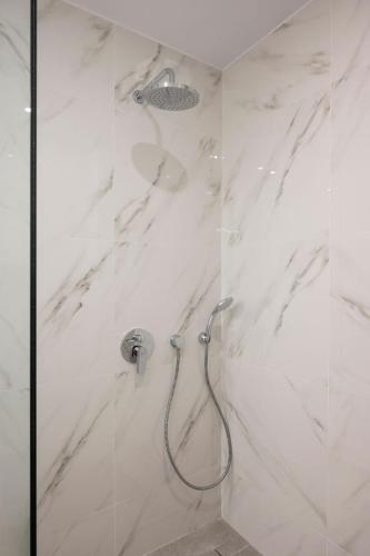 a bathroom with a shower with white marble at Kyma beach accommodation Delfini apartment with spa jaccuzzi 6 guests in Kolymvari