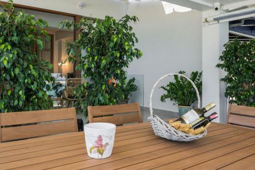 a picnic table with a basket of wine bottles at Kyma beach accommodation Delfini apartment with spa jaccuzzi 6 guests in Kolymvari