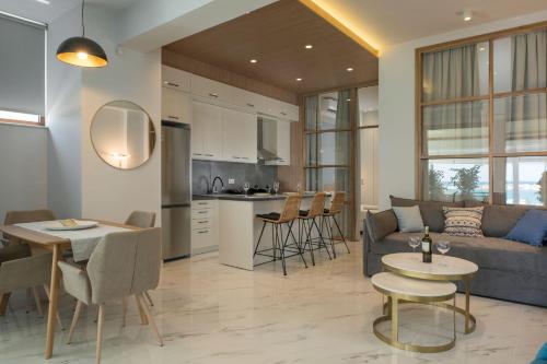 a living room and kitchen with a couch and a table at Kyma beach accommodation Delfini apartment with spa jaccuzzi 6 guests in Kolymvari