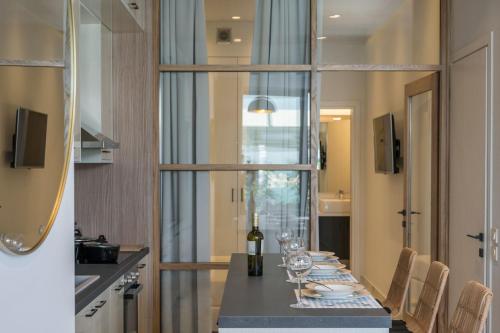 a dining room with a table with wine glasses at Kyma beach accommodation Delfini apartment with spa jaccuzzi 6 guests in Kolymvari