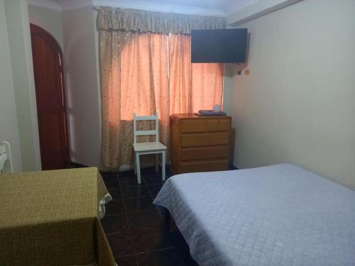 - une chambre avec 2 lits, une commode et une fenêtre dans l'établissement Posada de Mary, à Pisco