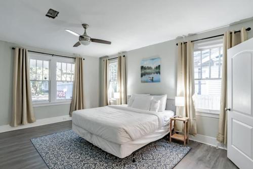 a white bedroom with a bed and windows at Modern Cottage on Michigan in Mobile