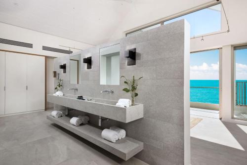 a bathroom with a sink and a large mirror at La Mer South, Luxury Oceanfront on Sapodilla Bay in Providenciales