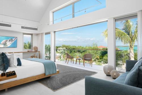 a bedroom with a bed and a view of the ocean at La Mer South, Luxury Oceanfront on Sapodilla Bay in Providenciales