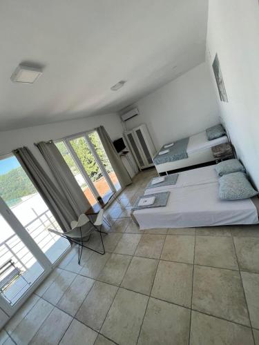 a bedroom with a bed and a large window at IN Villa Guesthouse in Sutomore