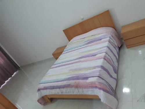 a bed with a multicolored blanket on it at chez Lourdes in Assomada