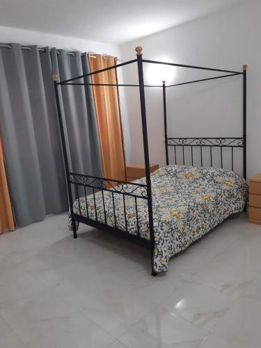 a black metal bed in a room at chez Lourdes in Assomada