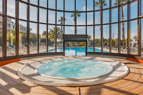 uma banheira de hidromassagem num quarto com uma grande janela em Golden Tulip Villa Massalia em Marselha