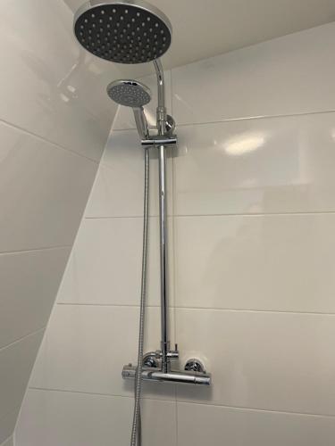 a shower in a bathroom with a shower head at Veldhorst Apartments in Leiden