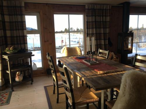 a dining room with a wooden table and chairs at New and cozy family cabin on Golsfjellet in Golsfjellet