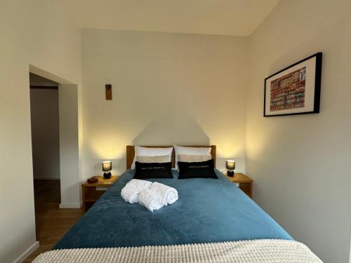 a bedroom with a blue bed with two pillows at Casas da Corujeira 2 in Porto