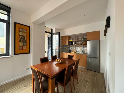 a kitchen with a wooden table and a refrigerator at Casas da Corujeira 2 in Porto