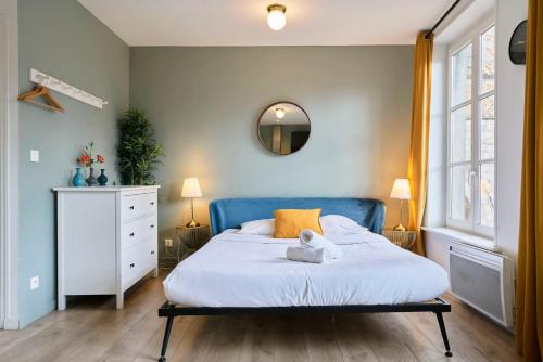 une chambre avec un grand lit avec une tête de lit bleue dans l'établissement Studio tout équipé, proche gares, à Lille