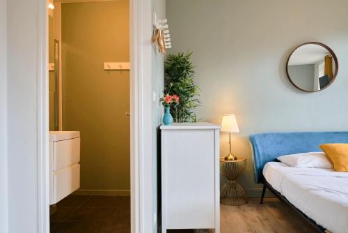 une chambre avec un lit et une table avec un vase de fleurs dans l'établissement Studio tout équipé, proche gares, à Lille