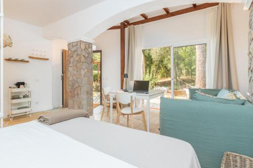 a bedroom with a bed and a desk with a laptop at Bacom House completa in Caldes de Malavella