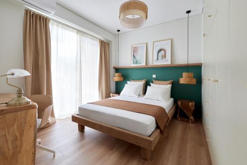 ein Schlafzimmer mit einem großen Bett und einer grünen Wand in der Unterkunft Athens Premium Suites - Sunny 2 Bedroom Suite with Parking in Athen
