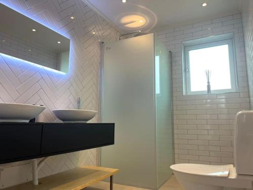 a bathroom with a sink and a shower and a mirror at Luxury Villa with Jacuzzi in Stockholm