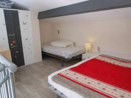 - une chambre avec 2 lits et une couverture rouge dans l'établissement APPT 2 PIECES MEZZANINE 28M2 + TERRASSE 10M2 REF 4038, à Le Castellas