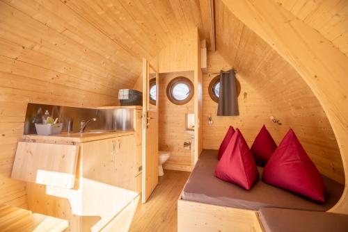 una casa pequeña con almohadas rojas en un banco en Camping Lazy Rancho - Eiger - Mönch - Jungfrau - Interlaken, en Interlaken