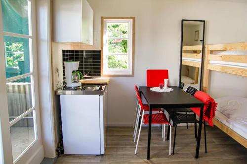 a small kitchen with a table and red chairs at Ferienbungalows Freest in Freest