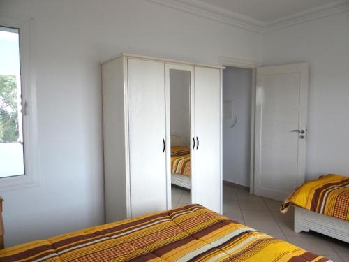 a bedroom with white cabinets and a bed at Residence Sterne in Ḩammām al Ghazzāz