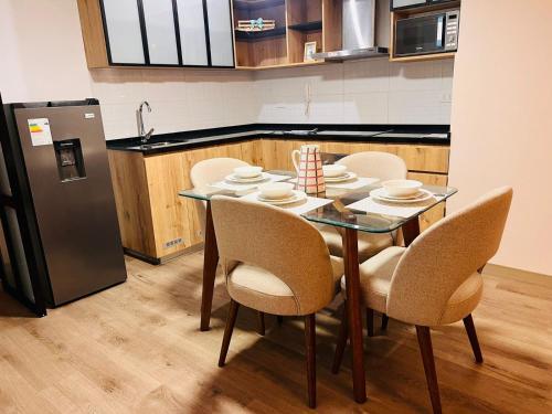 a kitchen with a table with chairs and a refrigerator at MONTERRICO POLO APARTS #13 - DPTO 2 dorm - Frente Embajada USA in Lima