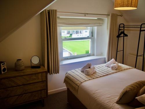 a bedroom with a bed with two towels on it at Combe Hill Apartments in Ilfracombe