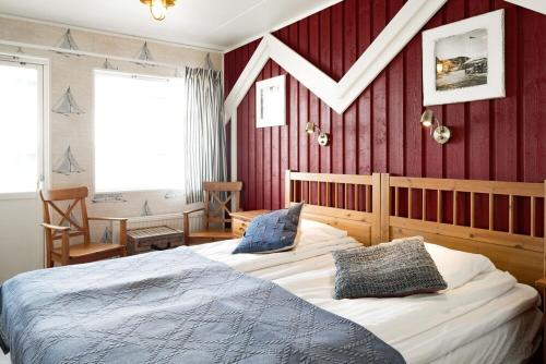 Ekenäs Havshotell في Sydkoster: غرفة نوم بسرير وجدار احمر