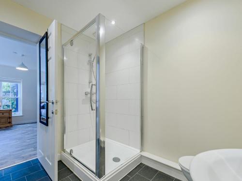 a shower with a glass door in a bathroom at 4 Bed in Tenby FB270 in Tenby