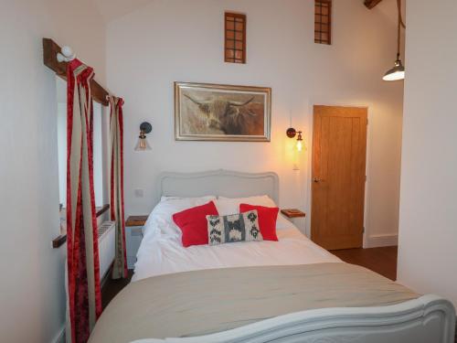 a bedroom with a white bed with red pillows at The Old Parlour in Rhyl