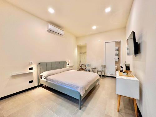 a bedroom with a bed and a desk and a tv at Cinque Terre Room Rental SULLA VIA in La Spezia