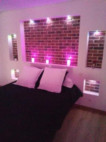 - une chambre dotée d'un lit avec des lumières violettes dans l'établissement magnifique loft avec jacuzzi et sauna privatif, à Ferrière-la-Grande