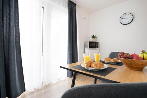 a living room with a table with fruit and juice at Moderne Apartments im Herzen von Osnabrück I private Tiefgarage I home2share in Osnabrück