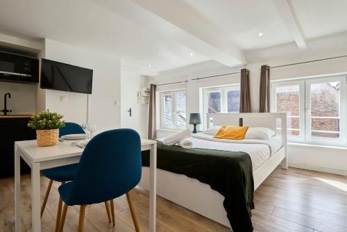une chambre avec un lit, une table et des chaises dans l'établissement Lille hypercentre gares - small suite, à Lille