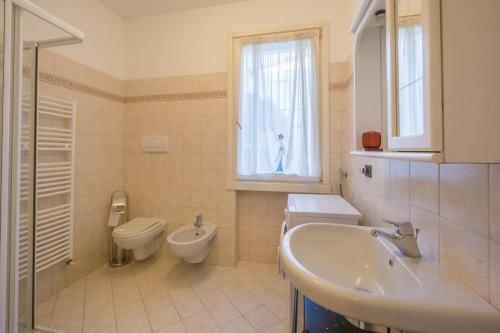 baño con lavabo y aseo y ventana en Casa Riello, a due passi dal lago, en Padenghe sul Garda
