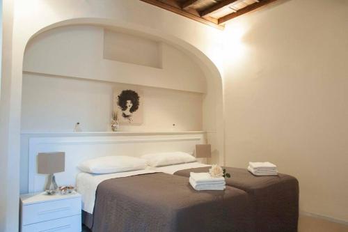 ein Schlafzimmer mit einem Bett in einem Zimmer mit einem Bogen in der Unterkunft Tornabuoni Charming Apartment in Florenz