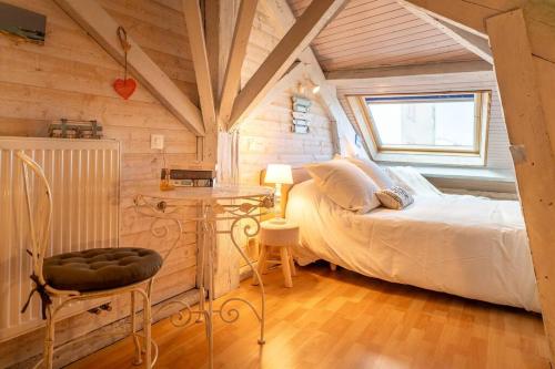 une chambre avec un lit, une table et une chaise dans l'établissement Charmant appartement en centre ville, à Arcachon